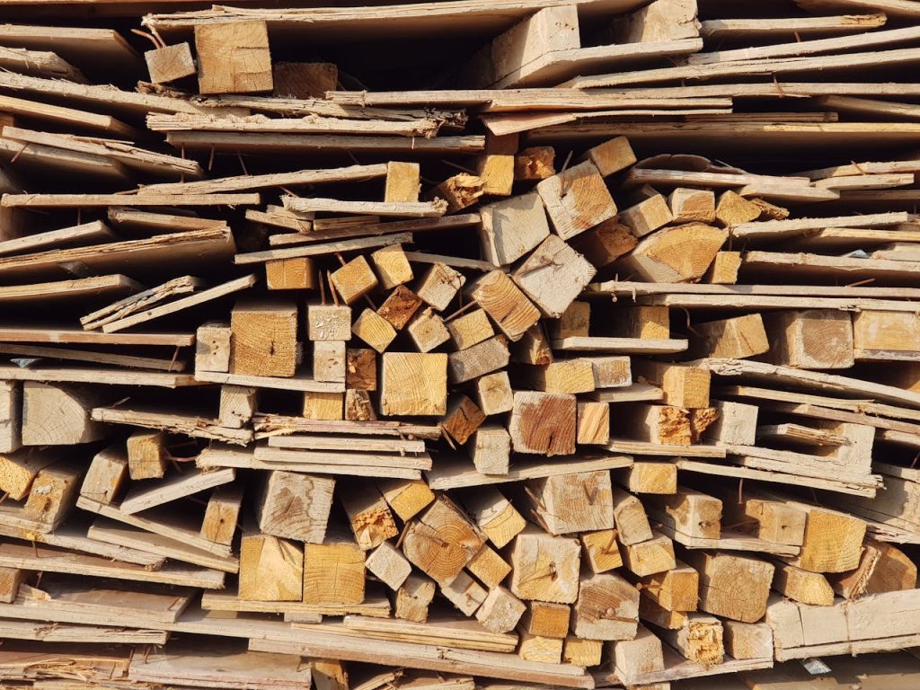 Close-up view of stacked wooden planks and logs highlighting an abundance of wood resources.